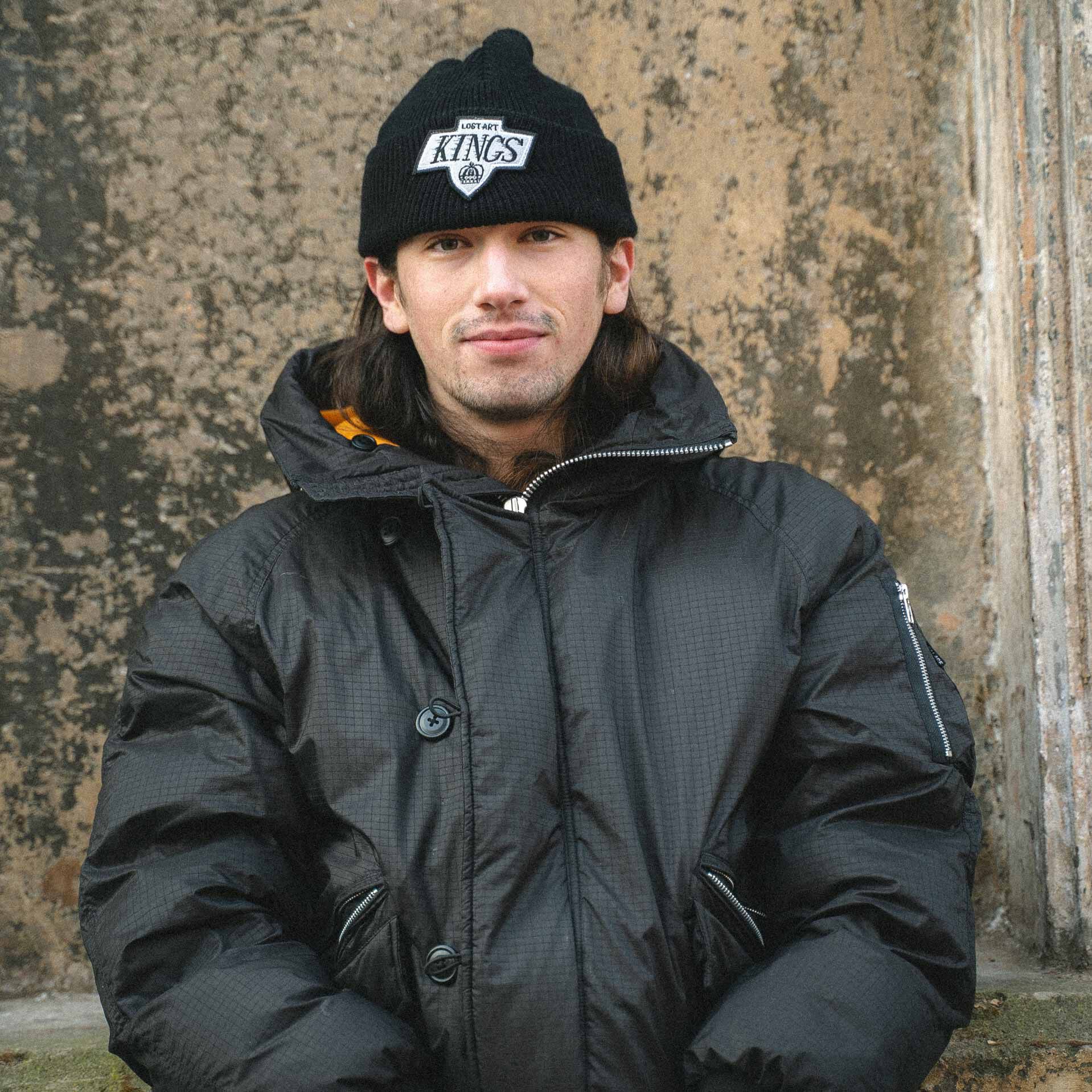 Skateboarder Charlie Birch doing a boardslide down a metal handrail in white and red Numeric shoes